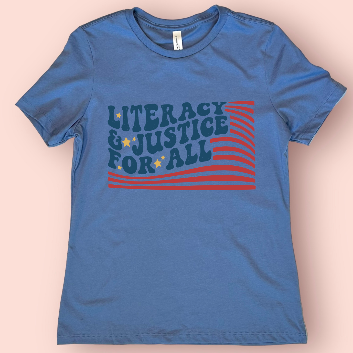 Blue t-shirt with 'Literacy & Justice for All' text and design on a beige background