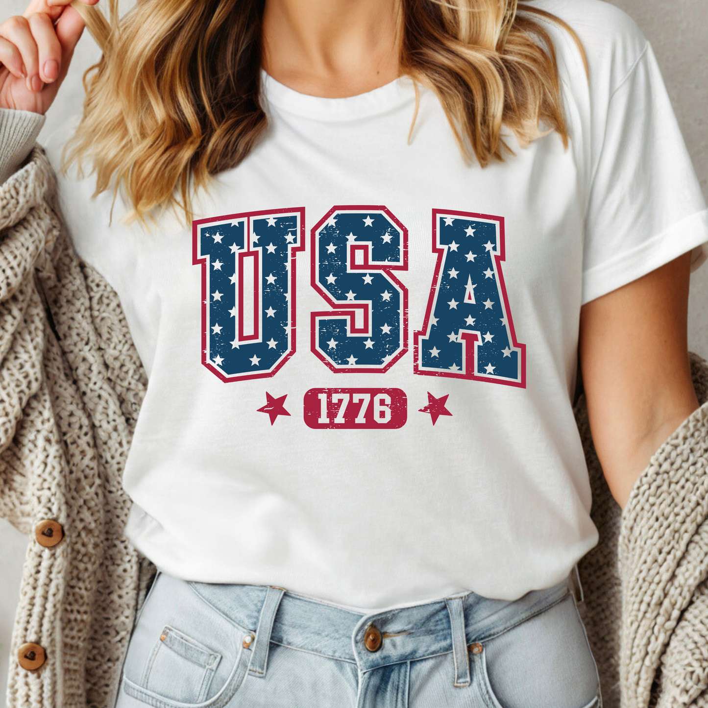 Person wearing a white t-shirt with 'USA 1776' design
